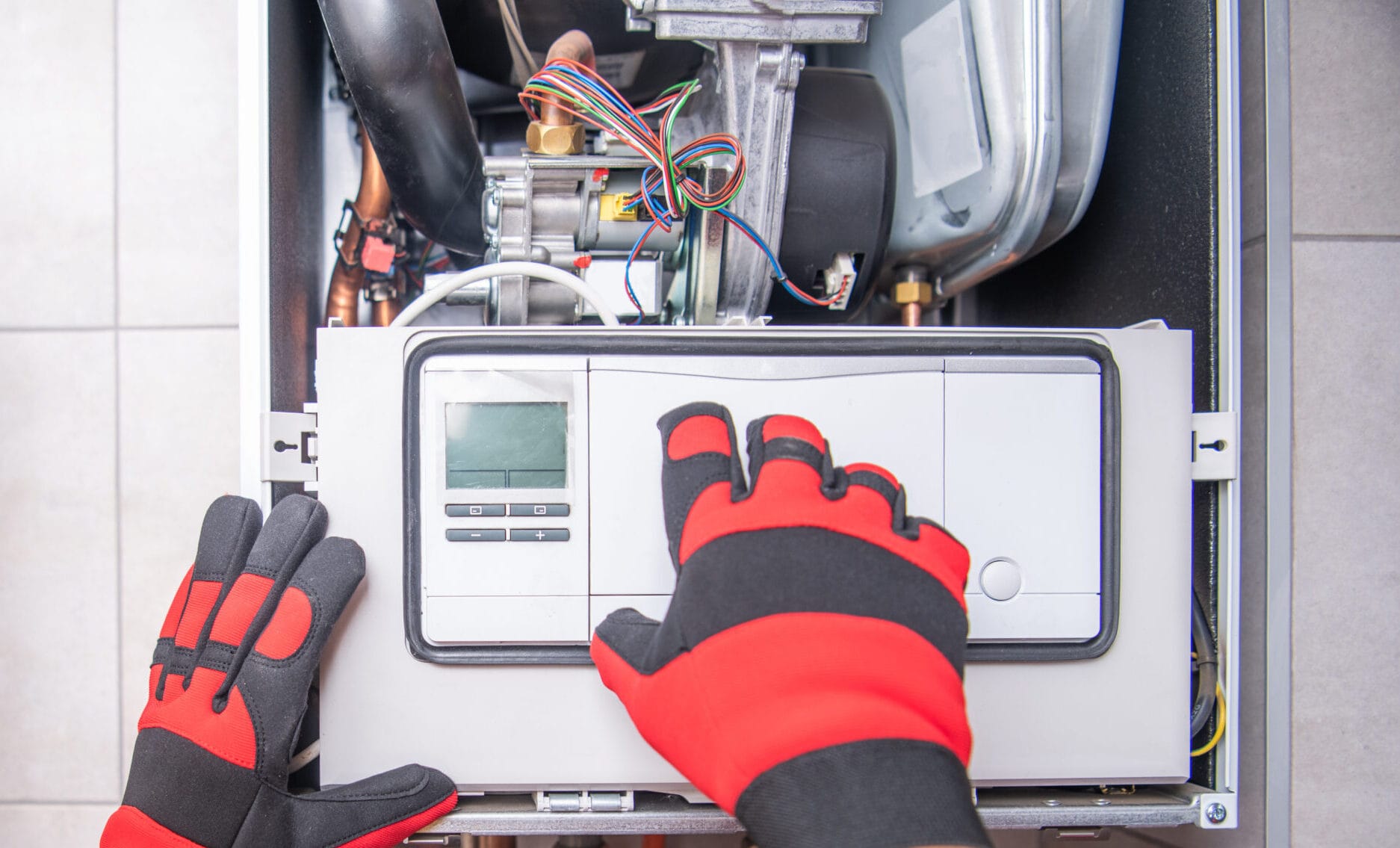 Caucasian HVAC technician repairing a gas heater, showcasing professional service in a residential setting.