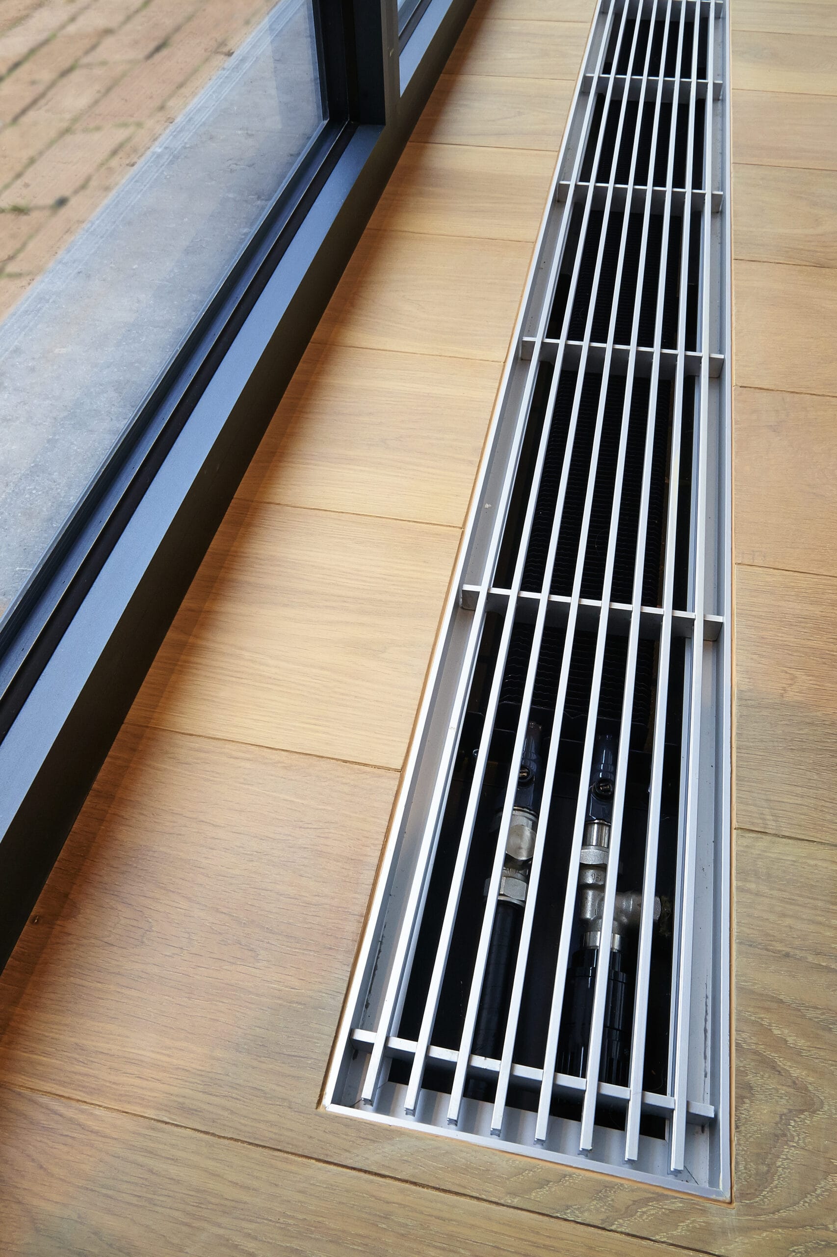 A hardwood floor with integrated heating and ventilation system, showcasing modern indoor air quality solutions.